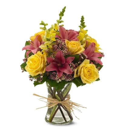 * Pink Asiatic Lilies
* Yellow Snapdragons
* Yellow Roses
* Pink Waxflower
* Clear Glass Vase
* Natural Raffia Bow
